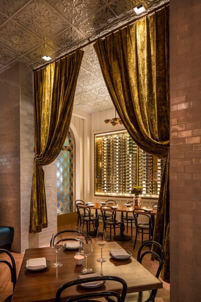 Private meeting room with tables and a lit wine display backdrop at Hotel Bijou, a stylish event space in San Francisco