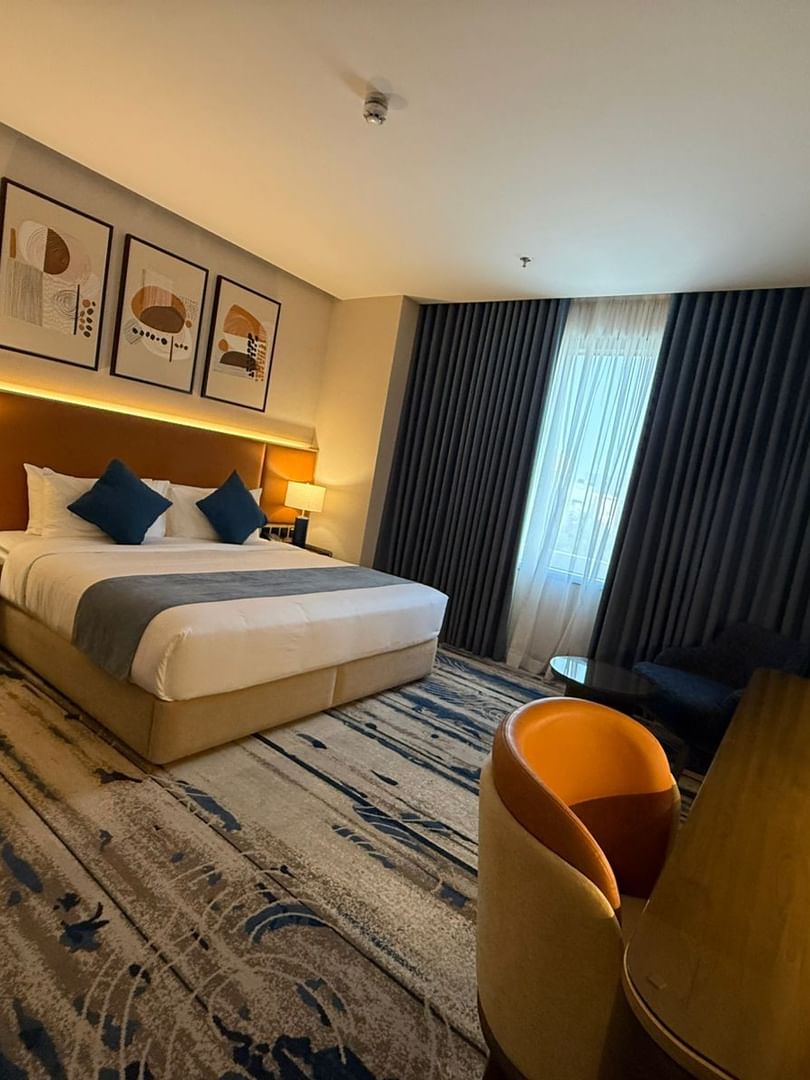 Work desk beside the bed and window-side couch in Deluxe Room at Warwick Jeddah Hotel & Spa