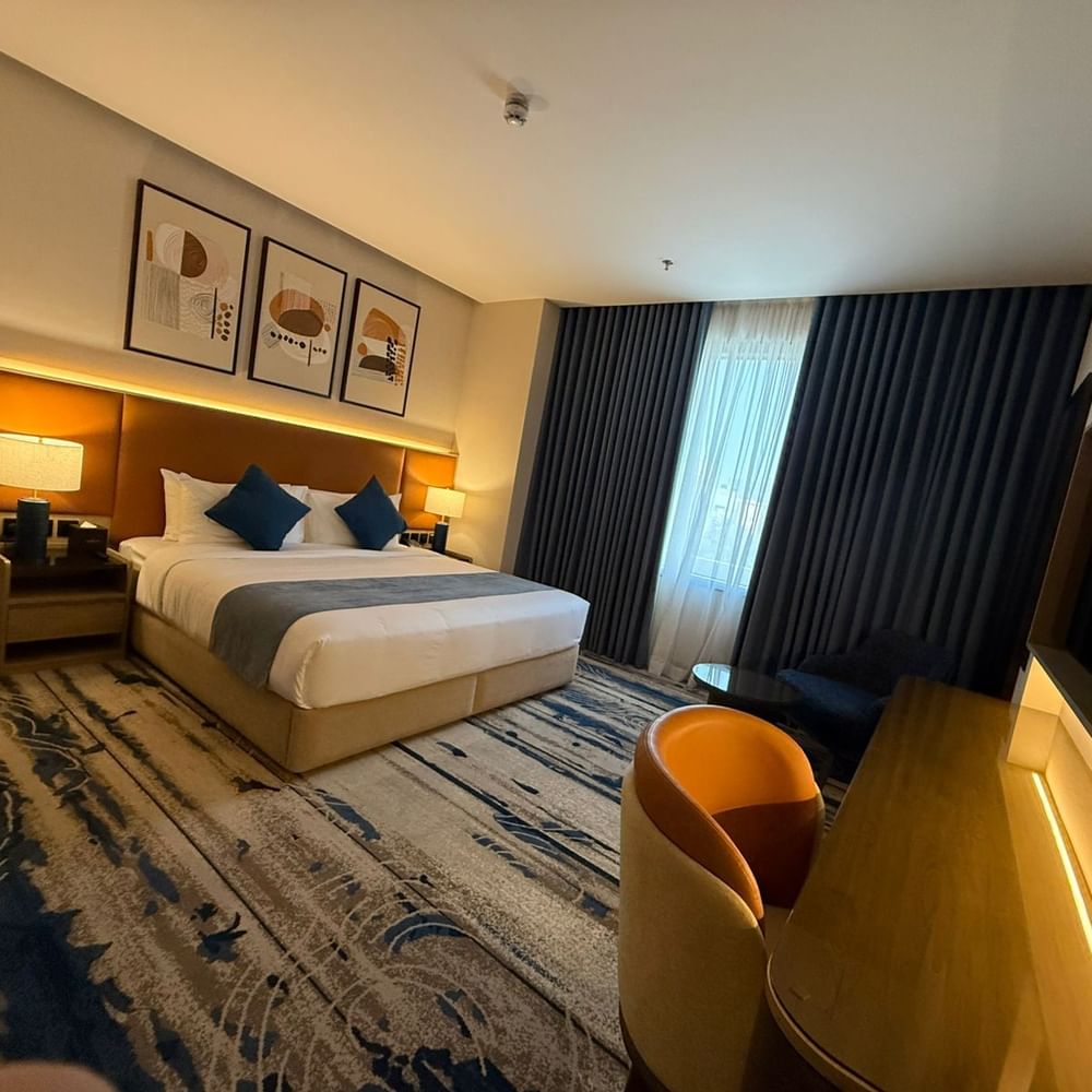 Work desk beside the bed and window-side couch in Standard Room at Warwick Jeddah Hotel & Spa