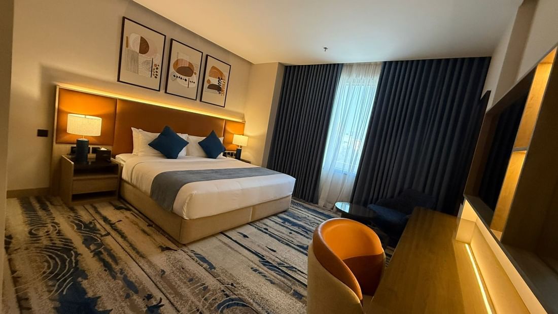 Work desk beside the bed and window-side couch in Junior Suite at Warwick Jeddah Hotel & Spa