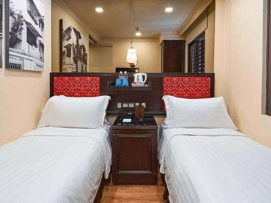 Nightstand & lamp between twin beds in Superior Twin at Nostalgia Hotel Singapore