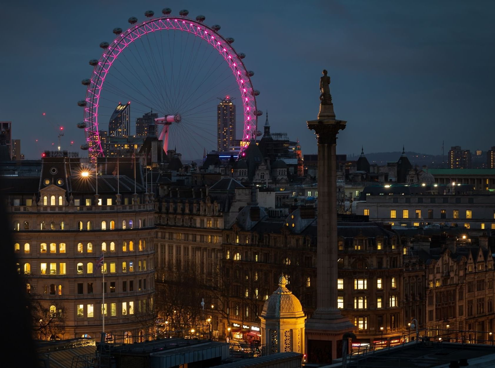 Night view of the London Eye from Park Plaza Westminster Bridge illuminated against the skyline near The Londoner Hotel