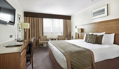 Premium King Room featuring a king-sized bed, a TV and two chairs at The Aberdeen Altens Hotel