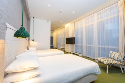 Executive Room with twin beds, TV, carpet and stylish hanging lights at Metropol Hotel