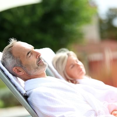 Senior couple relaxing on the sun beds at Originals Hotels