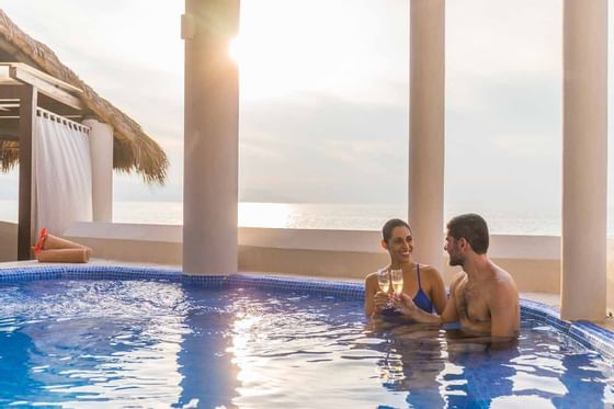 A couple drinking champagne in the pool at Buenaventura Grand