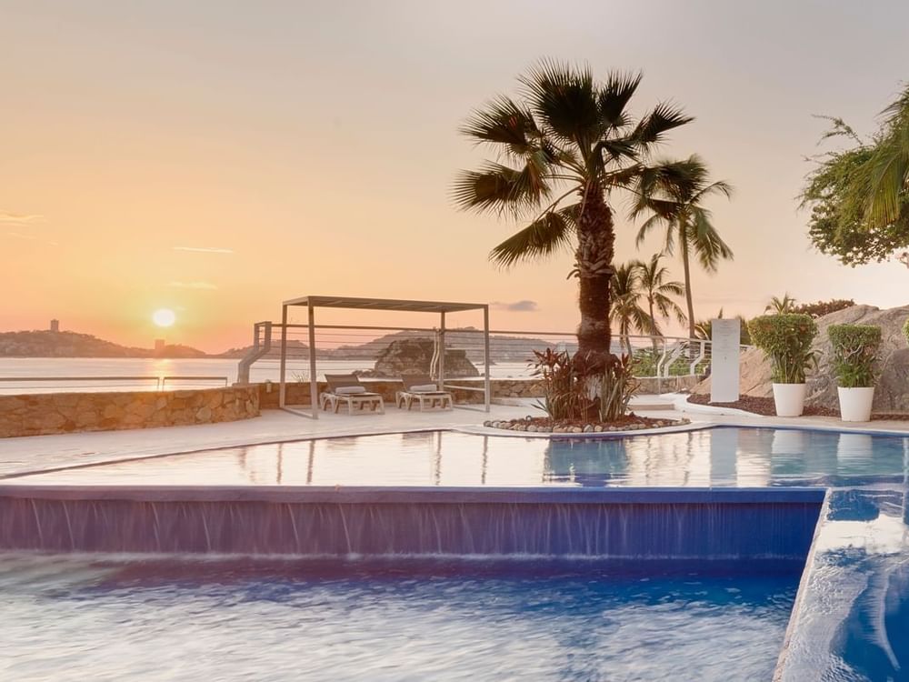 Outdoor pool with loungers at FA Hotels & Resorts