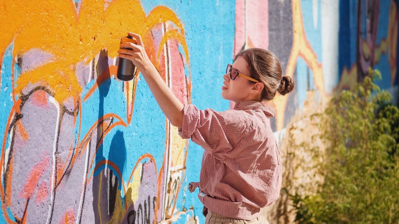 A woman painting a colorful mural in Chilliwack