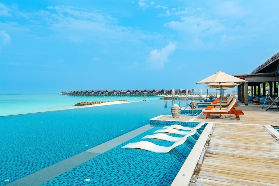Breeze poolside dining and bar sitting area with chairs near the infinity pool