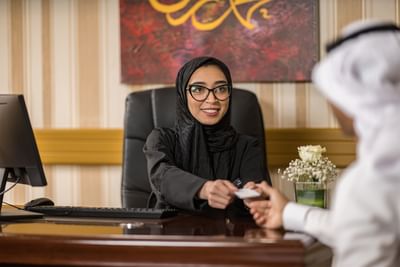 A receptionist associating with a guest at Elaf Al Taqwa