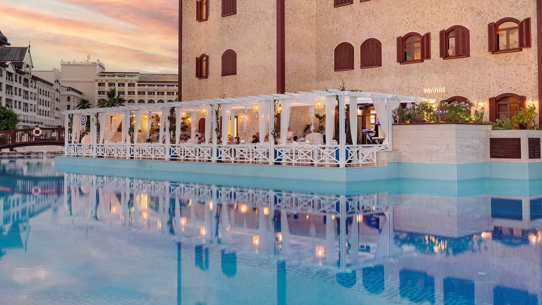 В ресторане Yamas Greek отеля Titanic Mardan Palace внешний вид с видом на бассейн создаёт впечатляющую атмосферу.