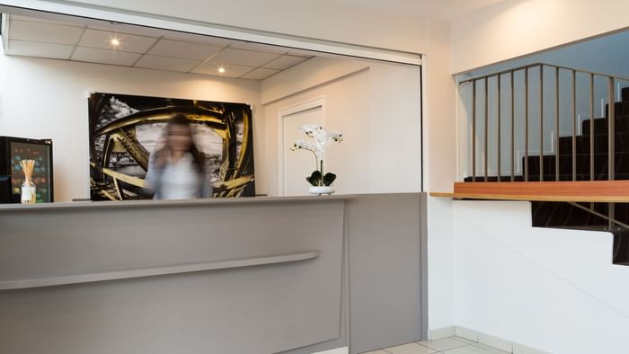 A receptionist at the reception desk in Hotel Agora