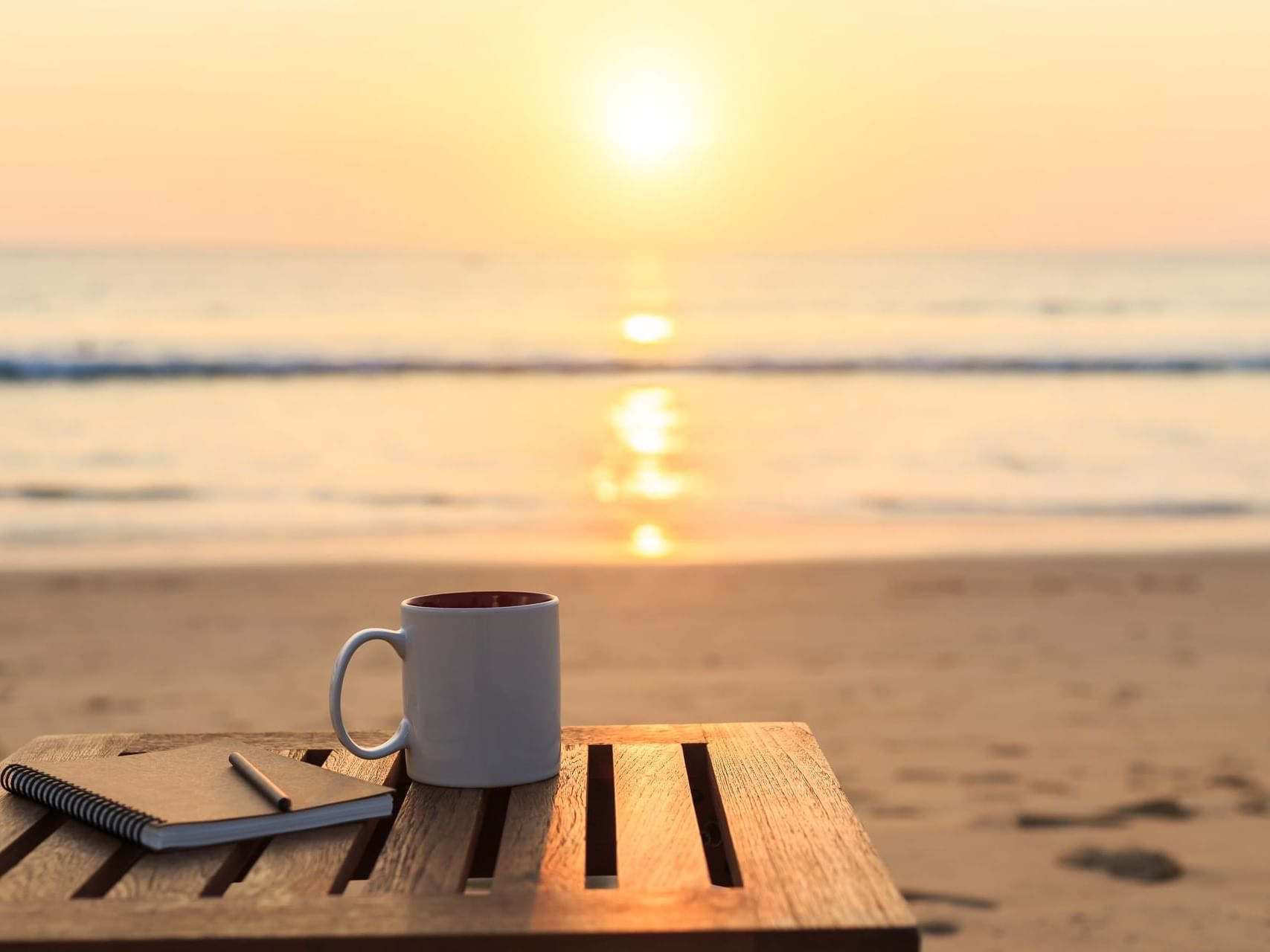 A mug and a book on a table in beach at ICONA Windrift