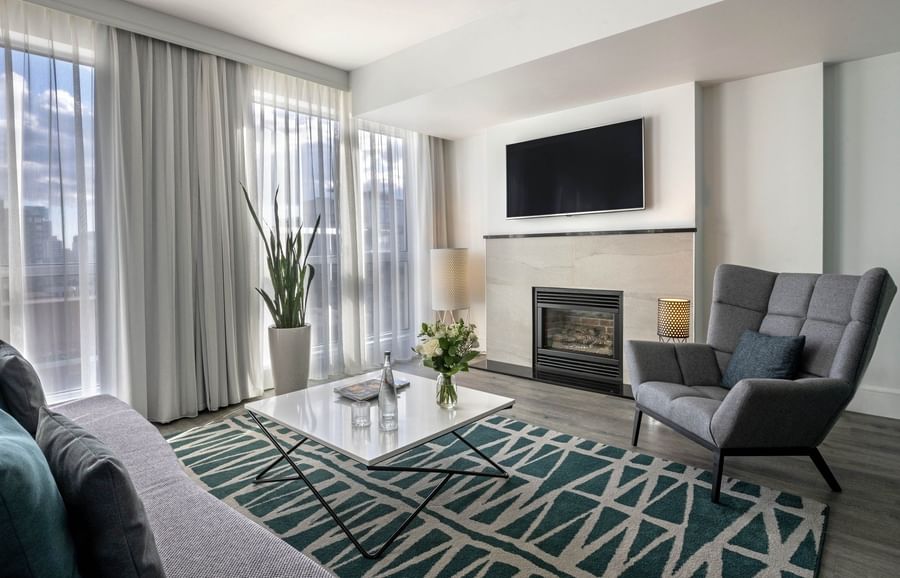 TV lounge with fireplace and plush sofa near window in Penthouse Crescent at Warwick Le Crystal Montreal