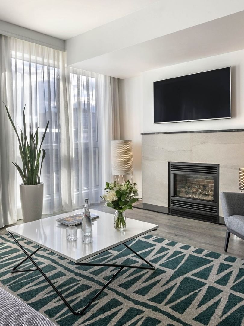 TV lounge with fireplace and plush sofa near window in Penthouse Crescent at Warwick Le Crystal Montreal