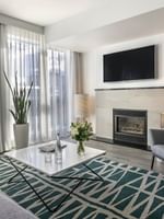 TV lounge with fireplace and plush sofa near window in Penthouse Crescent at Warwick Le Crystal Montreal