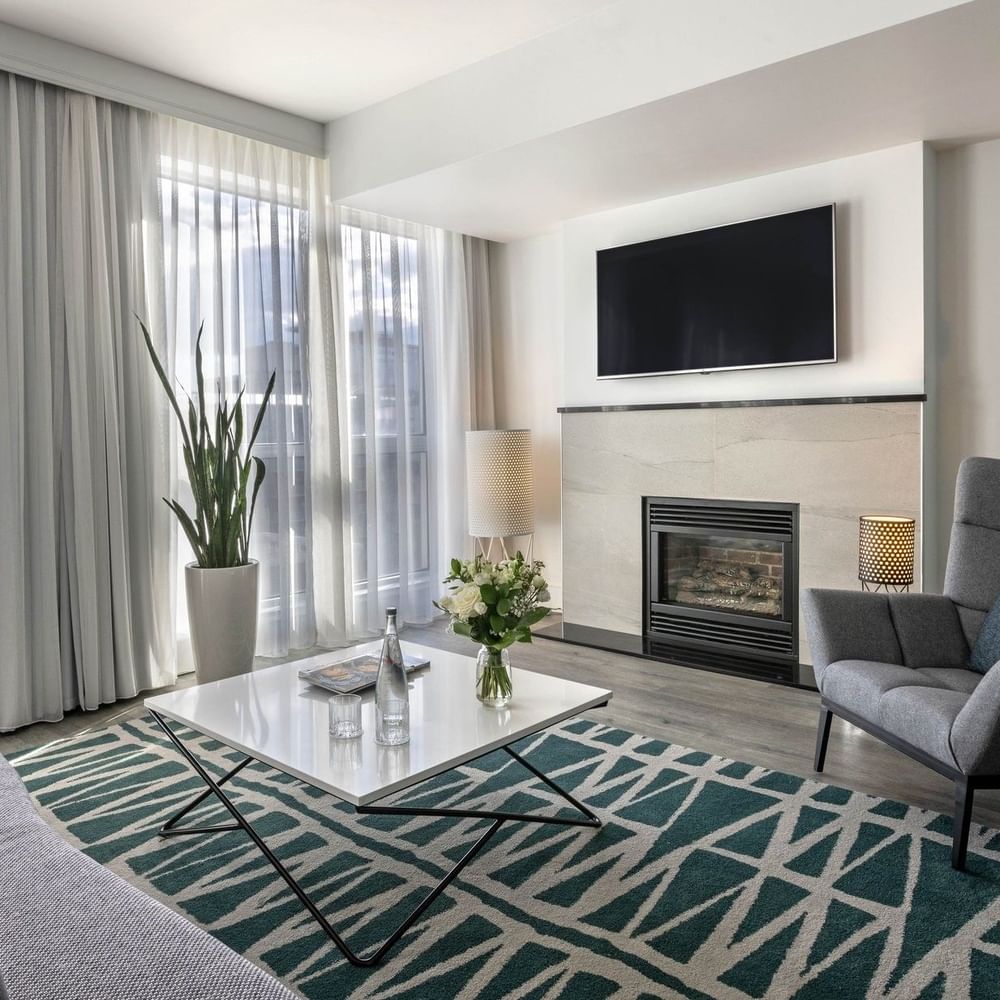 TV lounge with fireplace and plush sofa near window in Penthouse Crescent at Warwick Le Crystal Montreal