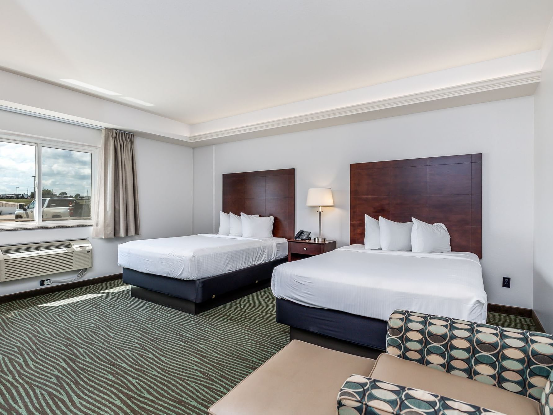 Nightstand by the cozy beds in Business Queen Resort View Room with patterned carpet at Off Shore Resort