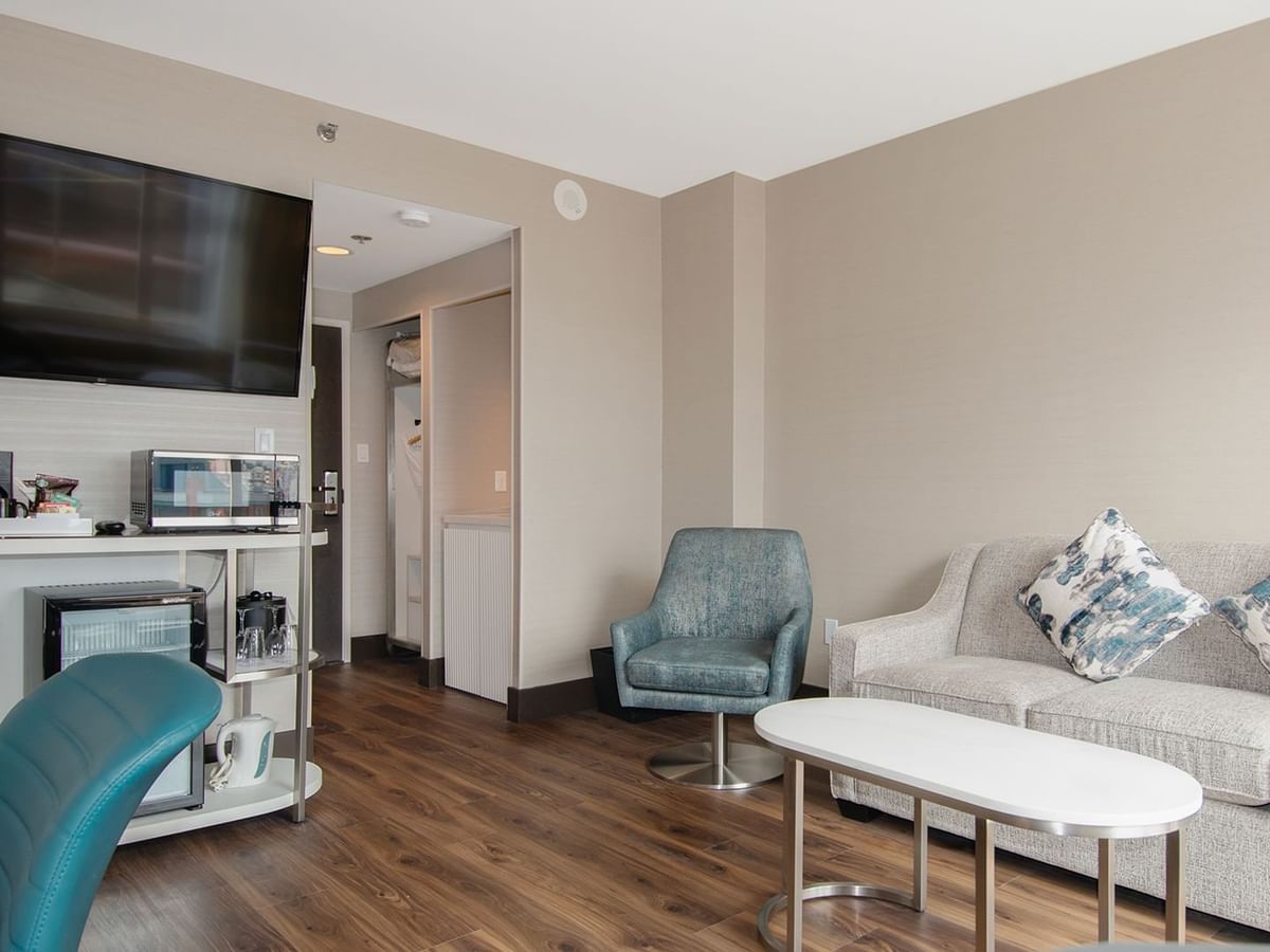 Hotel guestroom with living room sofa, TV and chair