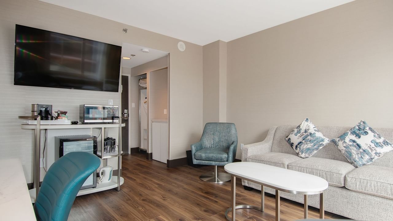 Hotel guestroom with living room sofa, TV and chair
