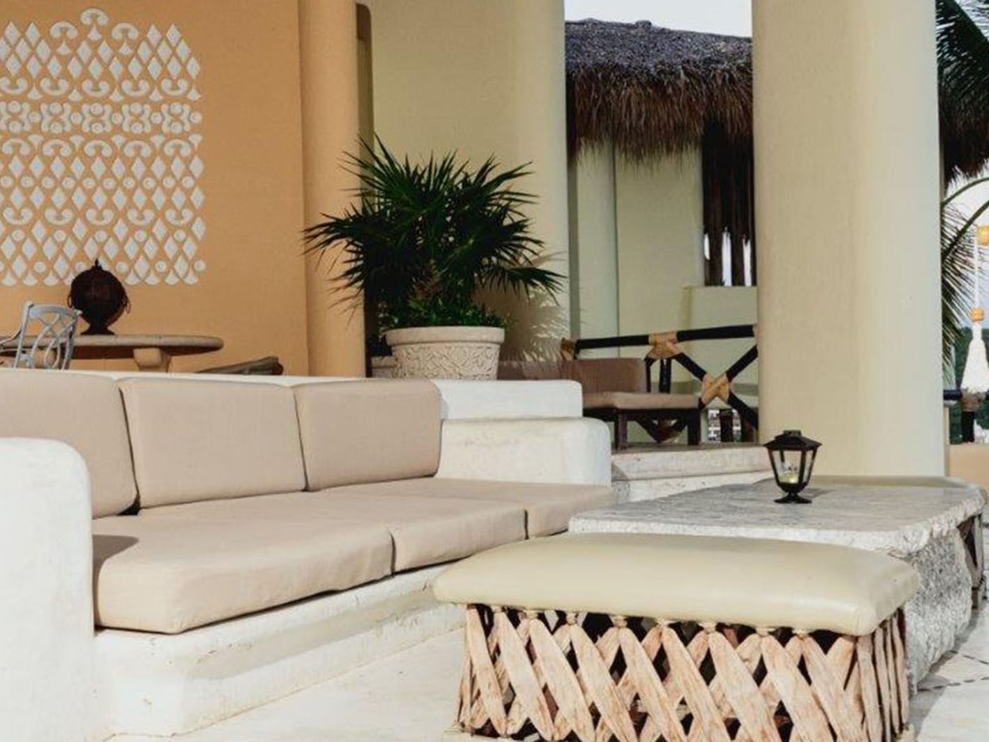 King Presidential Suite Outdoor terrace with white stone seating and a woven ottoman at Quinta Real Huatulco
