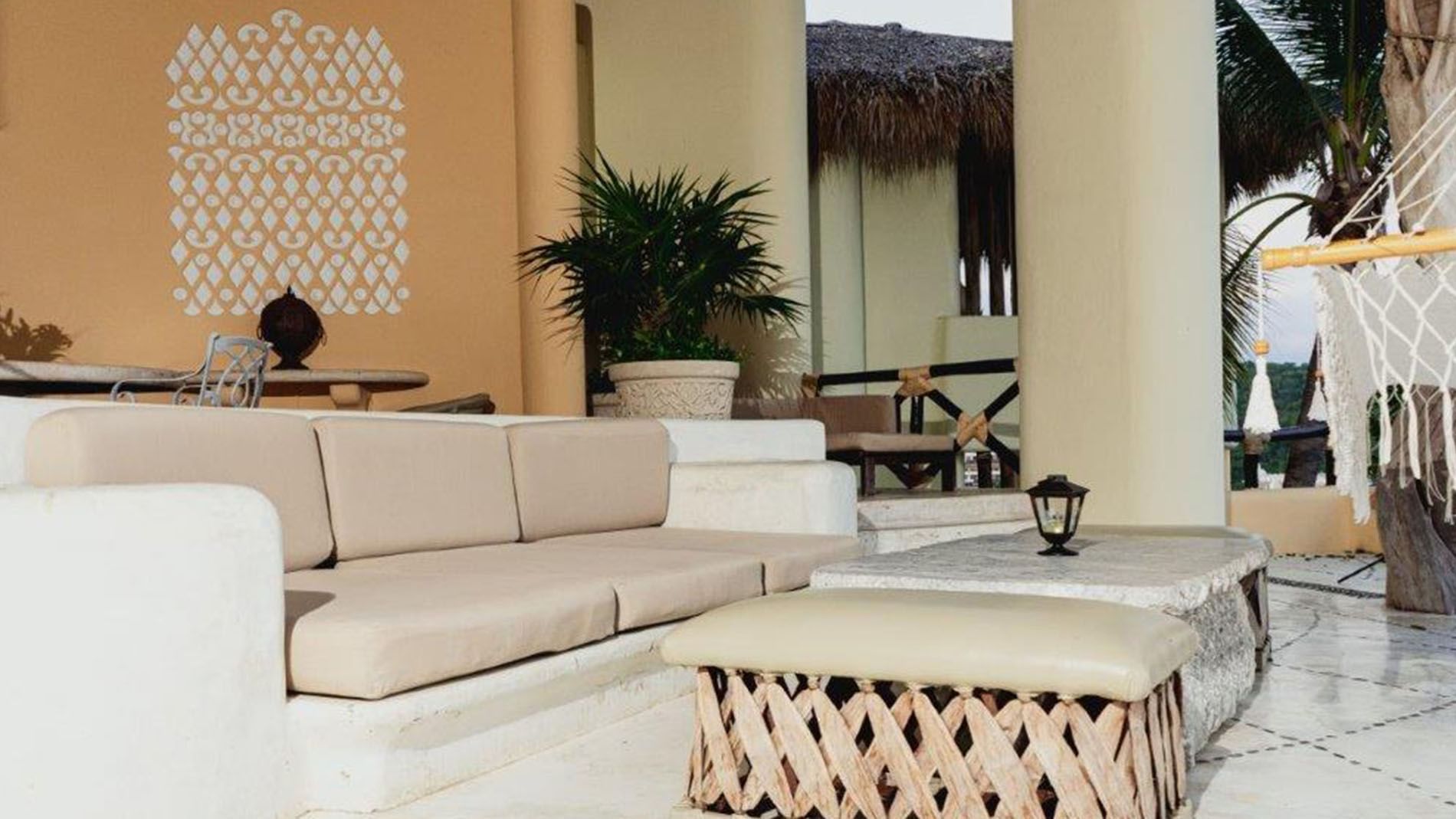 King Presidential Suite Outdoor terrace with white stone seating and a woven ottoman at Quinta Real Huatulco
