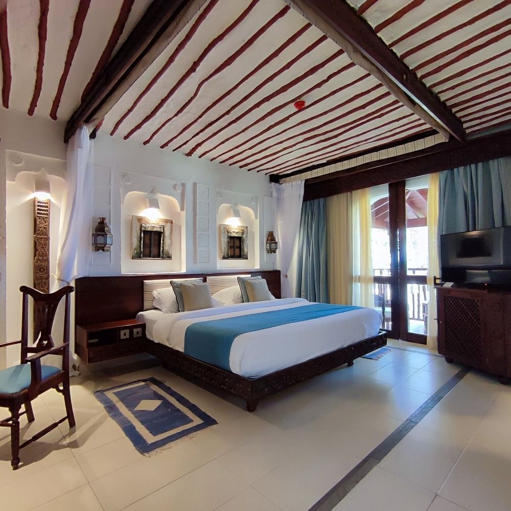 Elegant Family Room with large bed, chair, and TV at Serena Beach Resort & Spa in Mombasa.