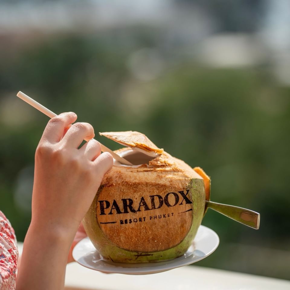 a person about to enjoy a fresh coconut that is branded
