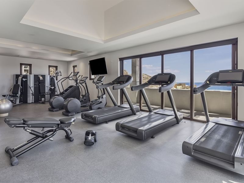 Exercise machines in the gym with sea view through windows at Live Aqua Resort & Residence