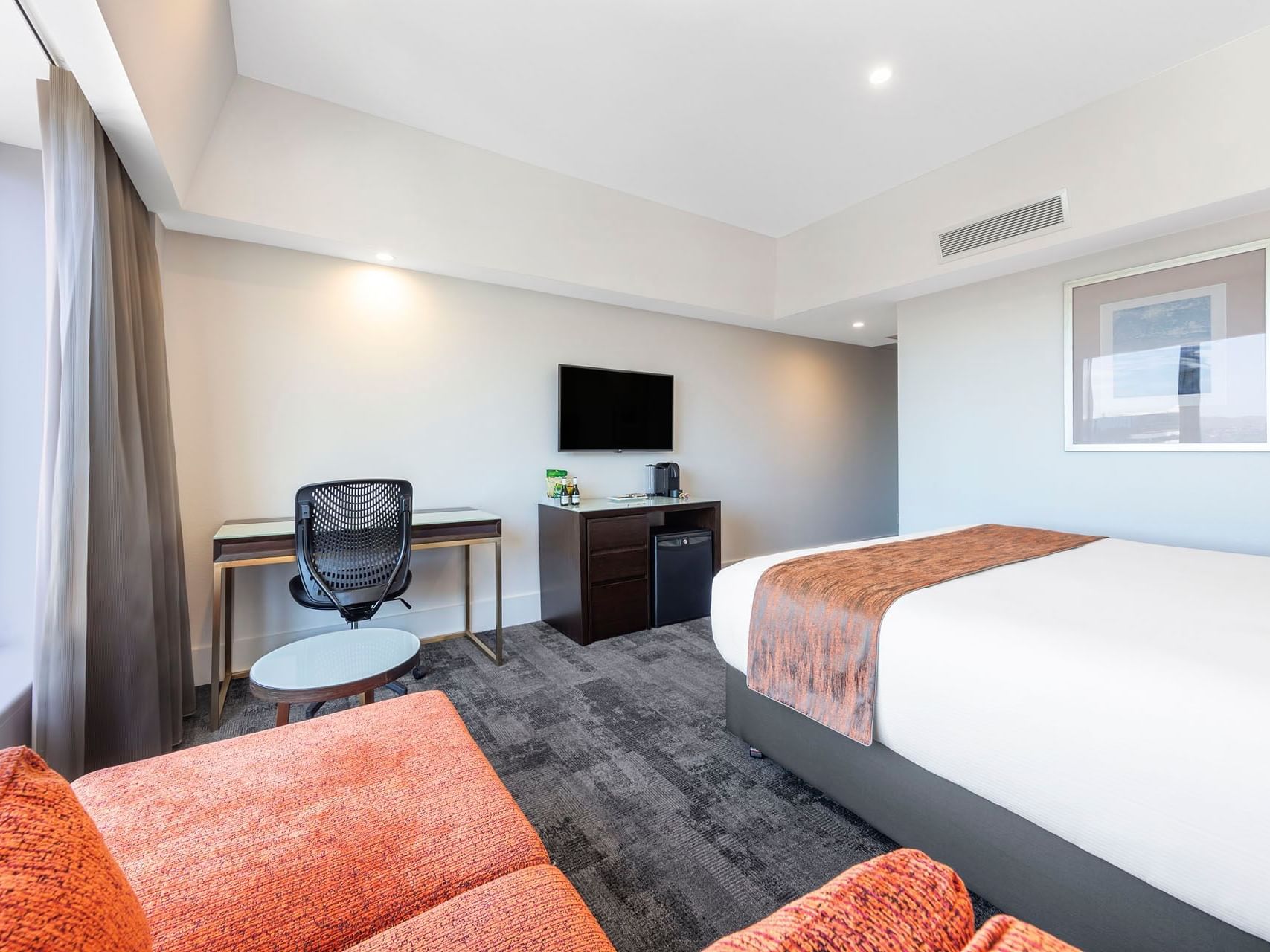 Work desk & TV by the king bed in a Room at James Cook Grand Chancellor
