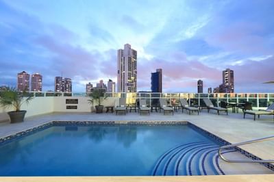 Rooftop pool with a city skyline and loungers by plants at MARlNN Place Financial District, best hotels in Panama City