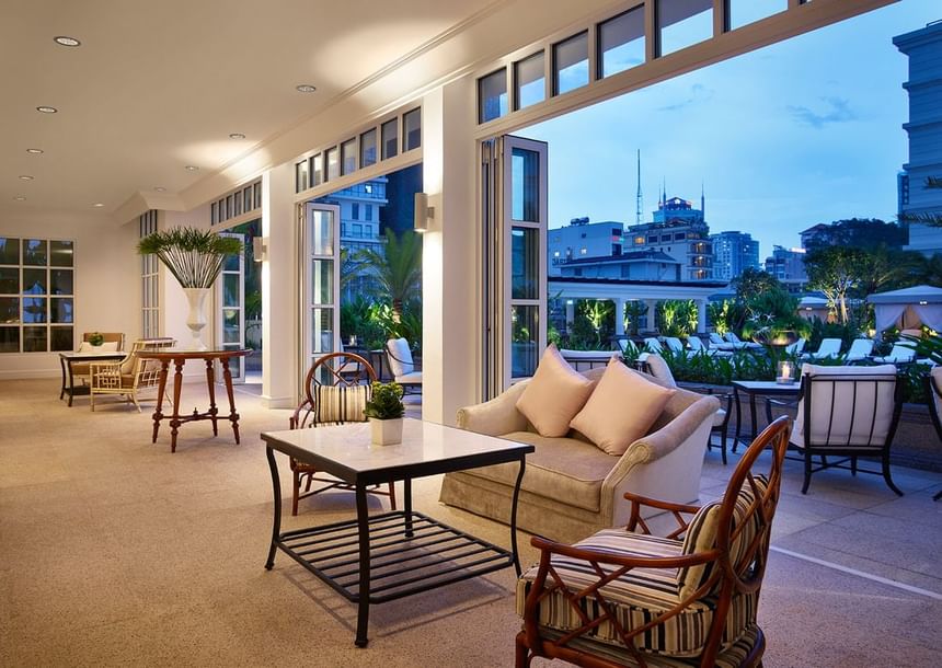 Pool House indoor lounge area overlooking the city through the open doors at Park Hyatt Saigon