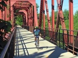 A man riding a bike on a bridge near Hotel 43