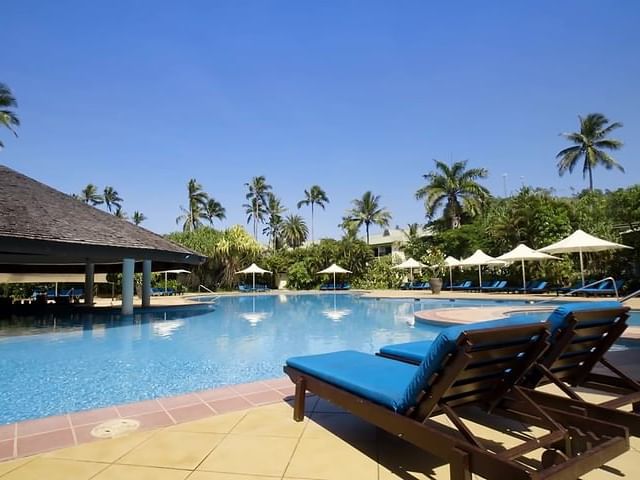 Lounge chairs by the swimming pool at The Naviti Resort - Fiji