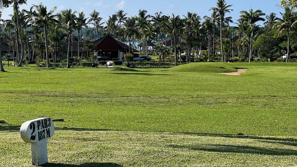 Golf course view with lush green field and palm trees at Warwick Le Lagon - Vanuatu, Efate.