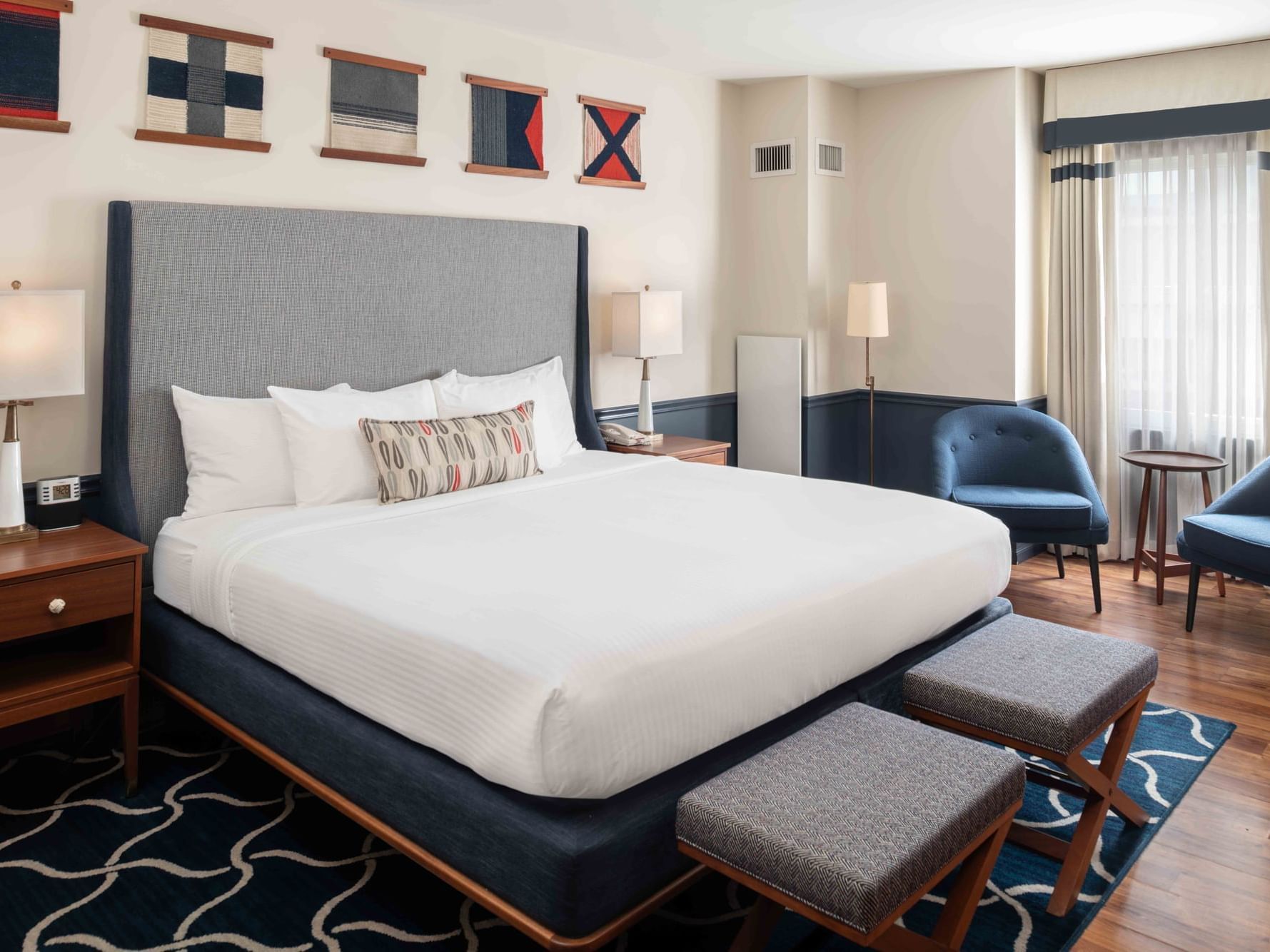 Two ottomans & loungers by the bed in Deluxe Room at Portland Harbor Hotel