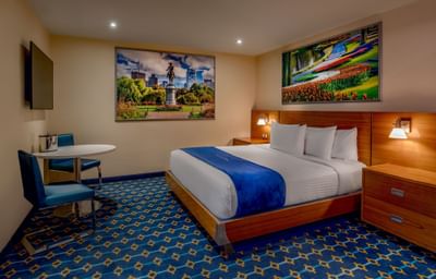 King Cabin with no windows featuring a bed, landscape art and a side painting near a table at Harborside Inn Boston