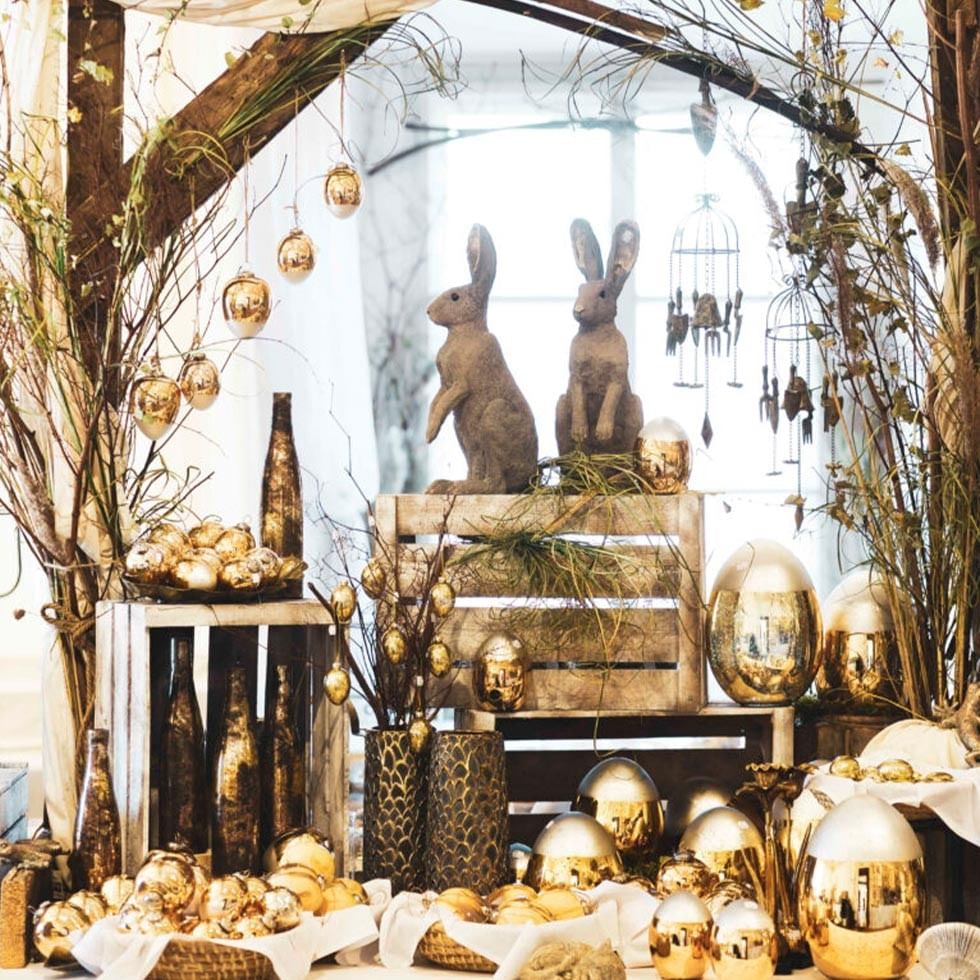 Golden Easter decorations and bunny figurines arranged on a table.