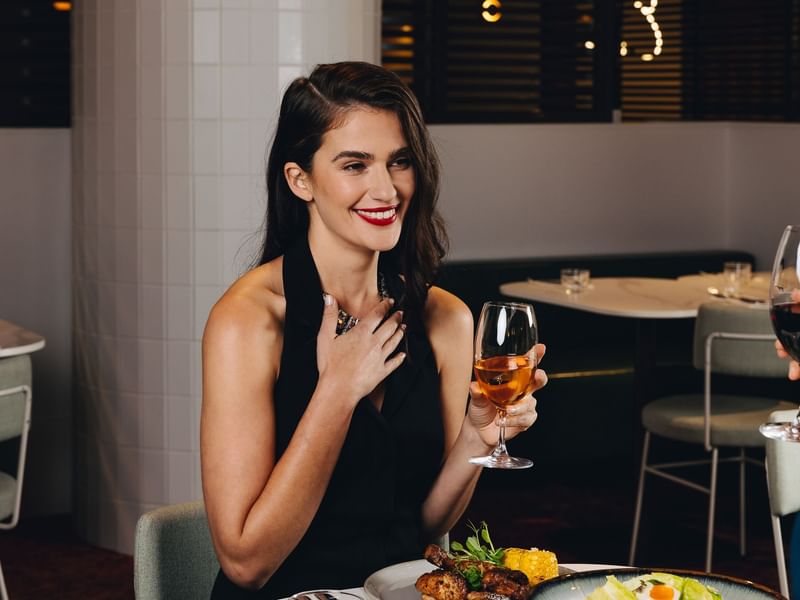 Lady having wine at Eva's restaurant at Pullman Melbourne City