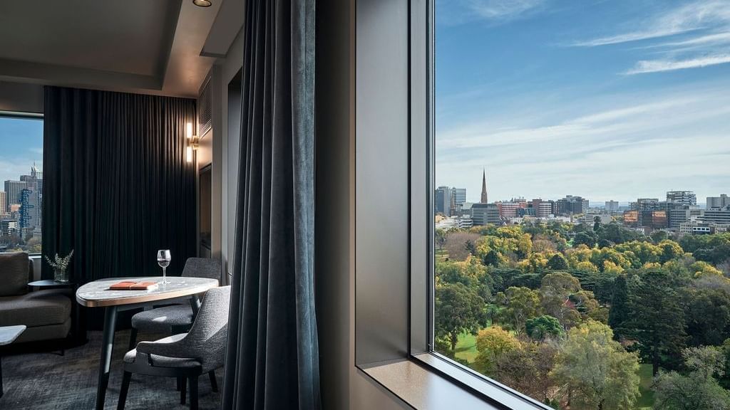 Superior Suite with windows overlooking parkland and city skyline at Pullman East Melbourne