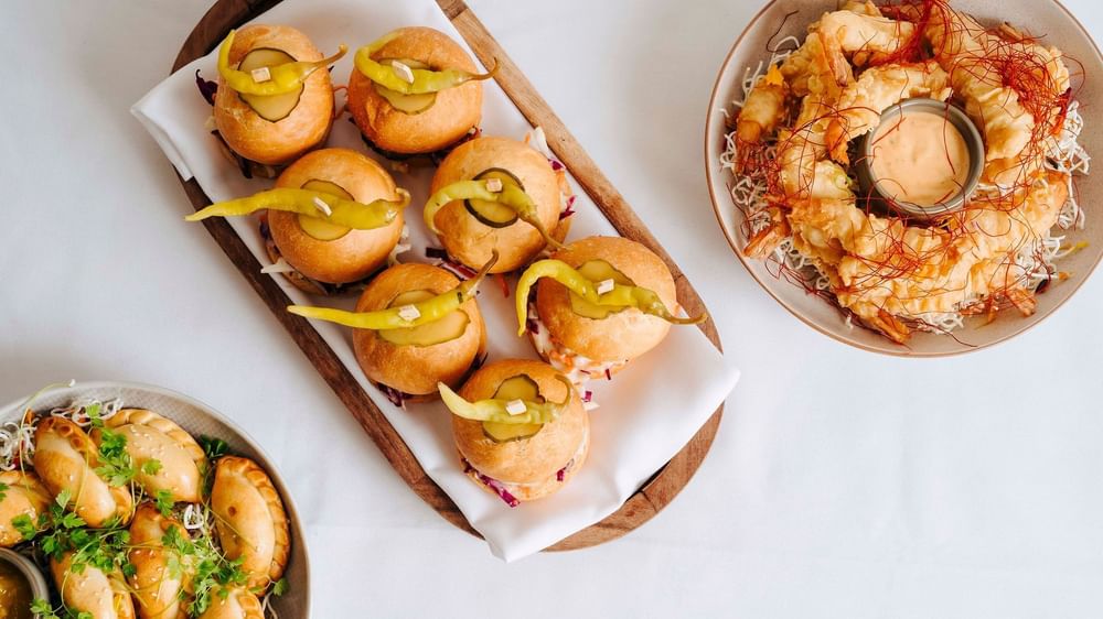 Assortment of appetizers featuring mini sliders, crispy shrimp, & empanadas in Parklands Room at Novotel Sydney Olympic Park