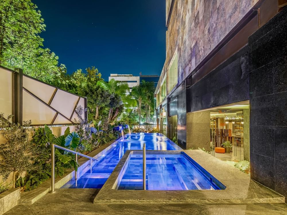 Outdoor swimming pool with illuminated lights at Grand Fiesta Americana