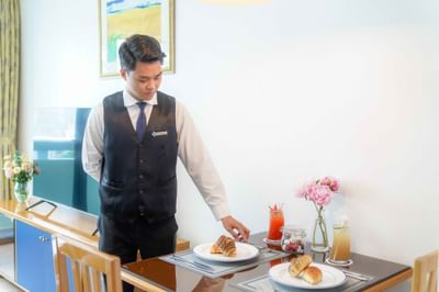 Waiter placing food on the table at Hanoi Daewoo Hotel