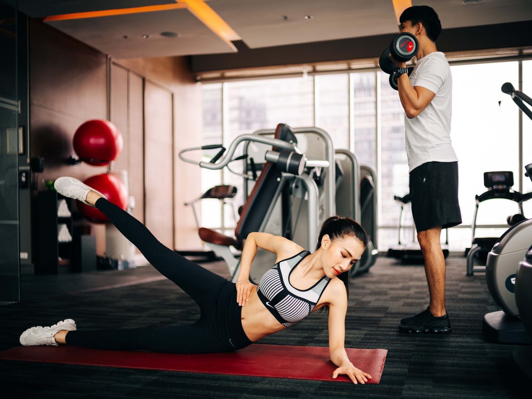 Man and woman working out in fitness center at Eastin Hotels