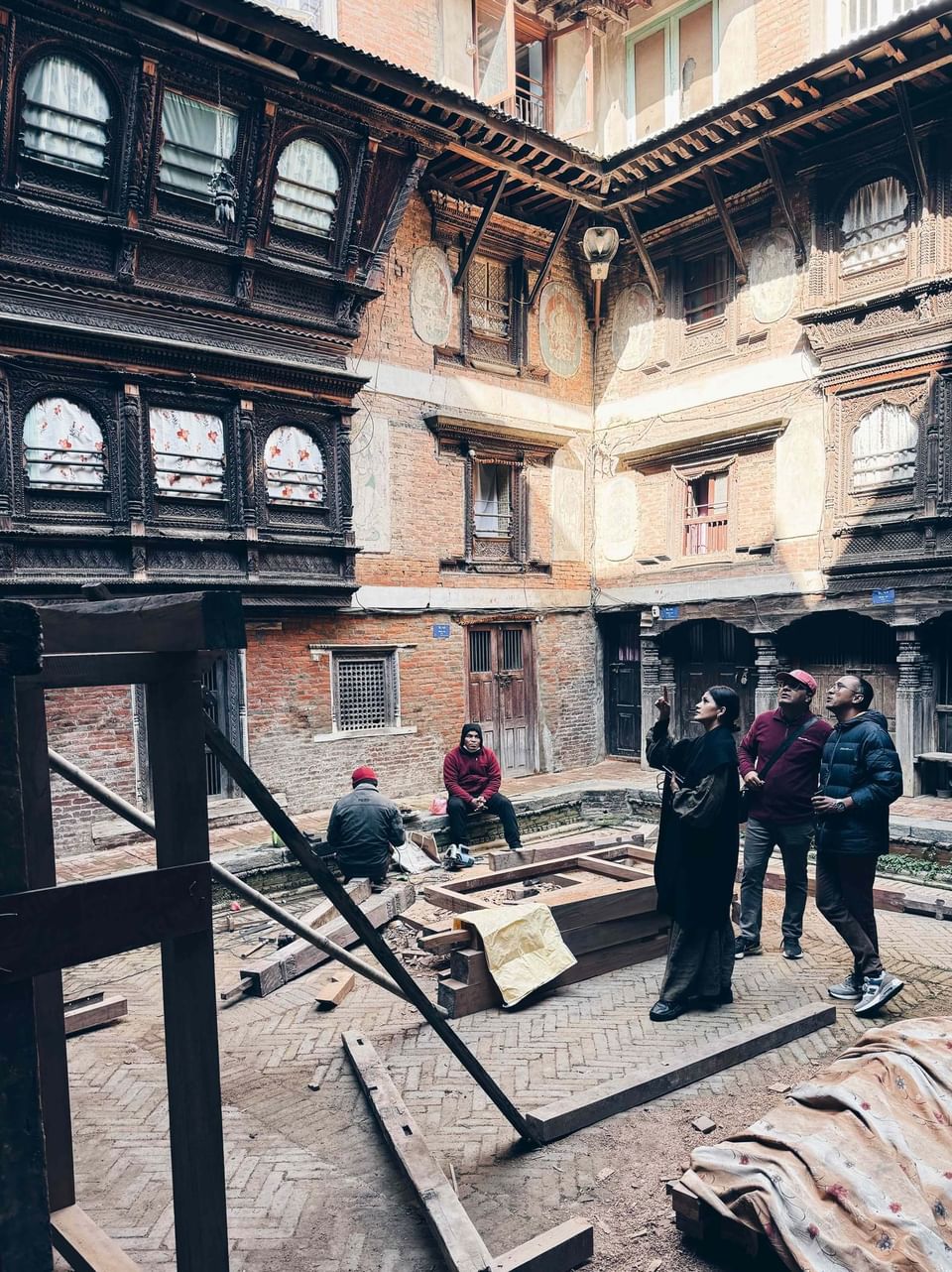 People working in an area surrounded by brick buildings at Dwarika's Hotel Kathmandu