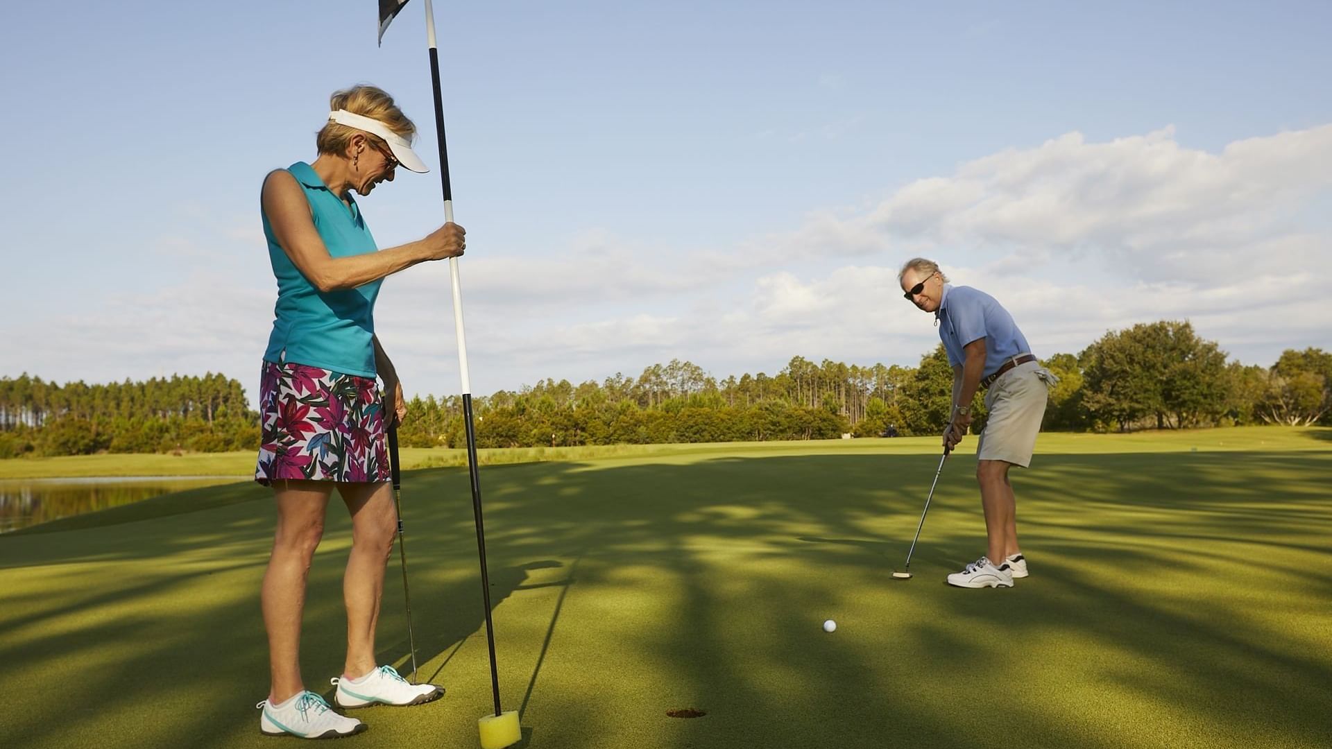 Couple on putting on the green at Origins Golf Course