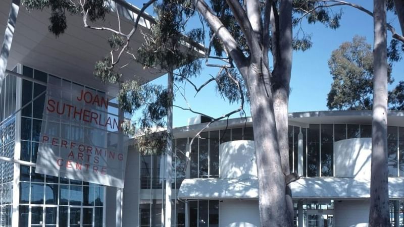 Joan Sutherland Performing Arts Centre building with large windows and trees in front.