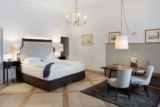 Junior Suite bedroom with a tufted bed at Schloss Hotel