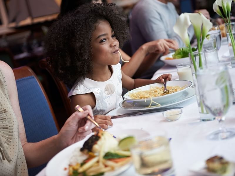 A kid enjoying her meal, while staying at Hotel Boston Harbor