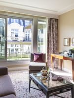 Purple cushions on a sofa by a glass table under mirrors in Executive Suite with Terrace at Warwick Paris Champs Elysées